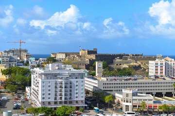 Naklejka premium Buildings in old San Juan, Puerto Rico with Castillo San Cristóbal, the largest fortification built by the Spanish in the New World, on the hill in the background 