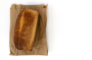 fresh bread brick or whole grain bread on paper bag isolated on white