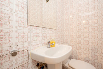 Bathroom with kitsch fixtures and tiles, white sink and square frameless mirror