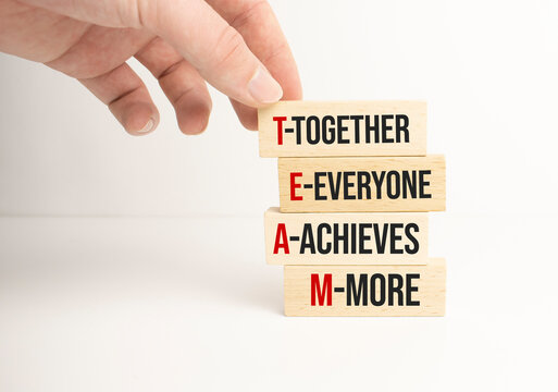TEAM, together everyone achieves more symbol. Wooden cubes with words