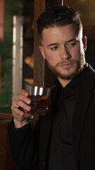 elegant man with glass of whiskey at a pub bar