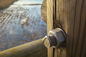 Closeup of metal bolt and nut spot welded.  Selective focus.