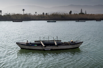Fototapeta na wymiar Paisaje del Parque Natural de La Albufera de Valencia en Cullera, con una barca típica del lago.