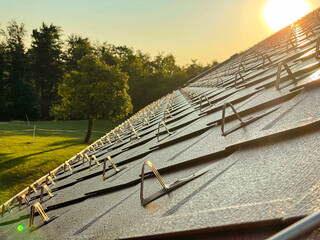 CLOSE UP: Sunset illuminates the snow guards installed on the renovated roof.