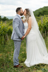 Fototapeta premium Wedding concept bride and groom man and woman kissing in the field celebrating happy after the marriage ceremony