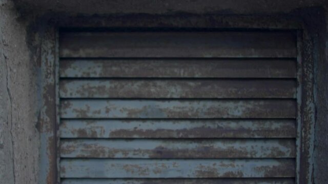 Old rusty ventilation grill in the outer concrete wall of a city building, conditioner blows the air out, smells of the restaurant kitchen. Close up.