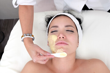 Facial treatment that allows women to rejuvenate. Dermatologist applies a facial treatment to a young white woman, who is lying in a clinic specializing in skin rejuvenation.