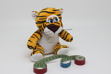 A toy tiger with a tailors measuring tape controls its weight.