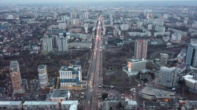 Aerial view Kharkiv city center Nauky avenue. Winter streets, sarzhyn yar and multistory modern high buildings in evening cityscape. Gray city with evening street lights