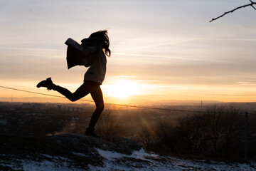 girl jumping for joy at sunset