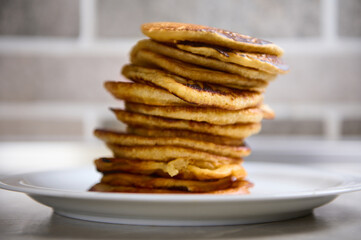 Close-up. A stack of freshly baked pancakes on a white ceramic plate. Shrove Tuesday concept