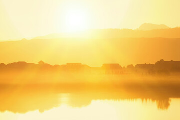 Foggy Sunset with silhouetted buildings and mountains