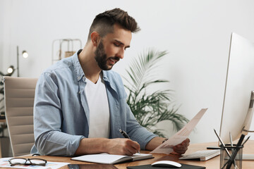 Man working with document at table in office
