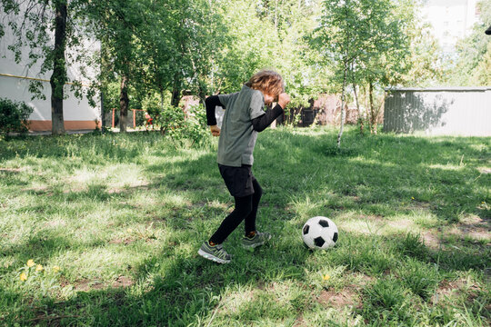 Kid playing football in the yard