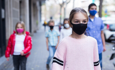 Schoolchildren in masks walking together on the street