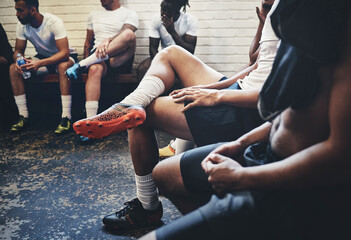 The big game's today. Cropped shot of a group of unrecognizable rugby players sitting in a locker room during the day.