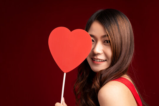 Beauty young model girl with Valentine red hearts on red background. Valentine's Day