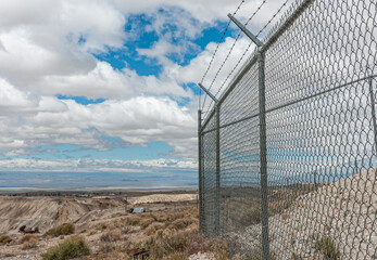 Tonopah, Nevada, US - May 19, 2011: Iron curtain heavy and high metal nasty fence with barbed wire...