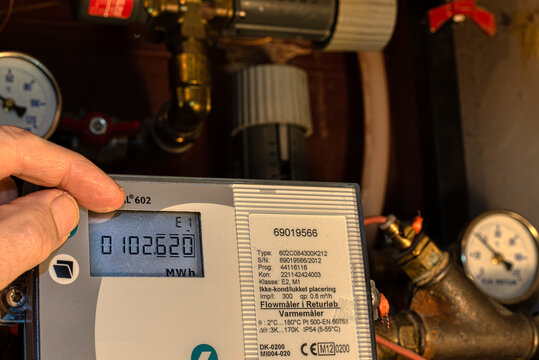 two fingers control the digital meter of the district heating to save energy