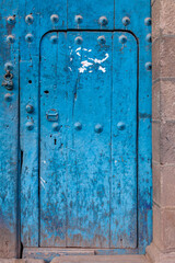 Beautiful old solid wood door, painted blue in a colonial building, city of Cuzco, Peru