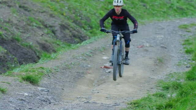 A mountain biker is blasting down a hill in slow motion