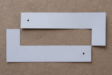 two letter Ls attempting to join as one on plain brown paper