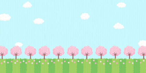 桜の木が咲きほこる春の風景　背景素材　バナーサイズ　青空と草原に桜の木