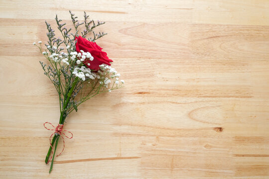 Red roses flower bouquet on wood background, banner with copy space for Valentine’s day concept, top view, flat lay
