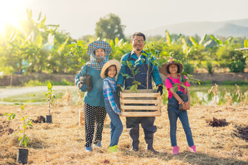 Family people standing for planting the tree in garden