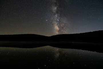 Milky way stars night dark sky south view with Sirius and Venus in Spruce Knob Lake West Virginia with mirror reflection in water of galaxy landscape view glowing silhouette - Powered by Adobe