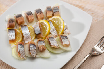 Mediterranean herring fillet served with sliced onion rings and lemon