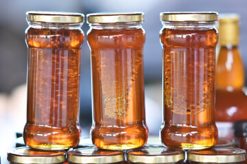 A jar of local honey with pure amber color. Inside the jar was a piece of the honeycomb it came from.