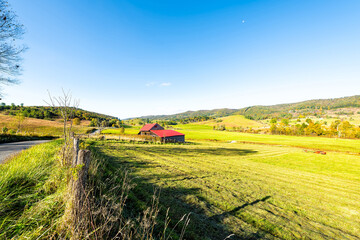 Wide angle landscape view of rural countryside farm rolling hills fall autumn forest trees in Allegheny mountains pastoral landscape in Blue Grass, Highland county in Virginia