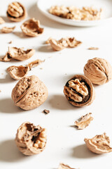 Cosy autumn aesthetic composition with dry  leaves, walnuts on white background. Flat lay, top view, copy space.