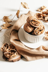 Cosy autumn aesthetic composition with dry  leaves, walnuts on white background. Flat lay, top view, copy space.
