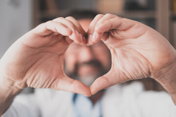 Man doing heart shape gesture with hands. Hand of male doctor making a love symbol. Healthcare...