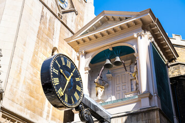 London, UK St Dunstan-in-the-West church in center of downtown district city of London with old architecture on Fleet street and clock and bells blue sky