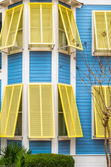 Seaside, Florida pastel blue and yellow painted colorful hurricane open window shutters...
