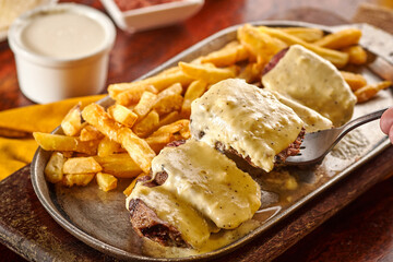 comida colombiana papas fritas con carne bañada en salsa de queso
