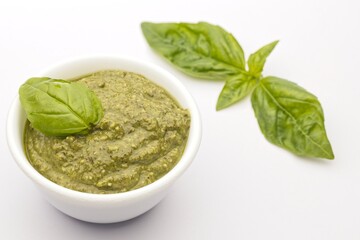 Homemade pesto and basil on white.