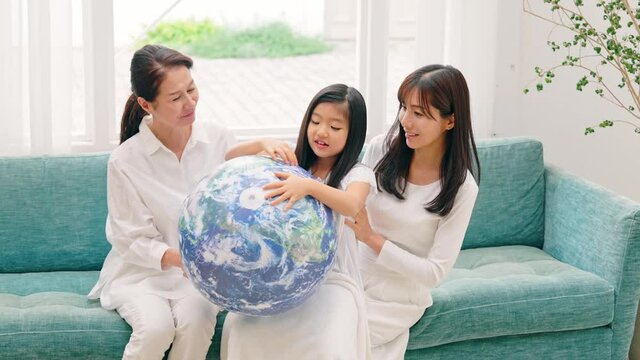 地球の模様のボールを持つ三世代家族　環境イメージ　SDGs