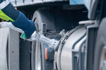 Der LKW Fahrer zieht deie LNG Tankpistole ab 