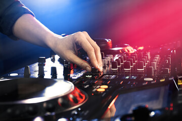 Fototapeta na wymiar DJ creating music on modern console mixer in night club, closeup