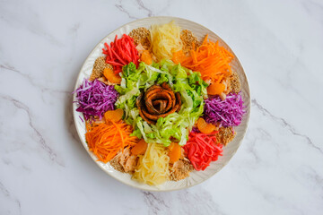 Modern chinese fish salad. Yusheng aka Prosperity Toss. Mixed variety of colorful vegetable slices...