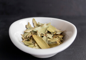 plato blanco con hojas de laurel sobre fondo negro