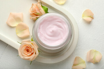 Fototapeta na wymiar Jar of organic cream and roses on white table, flat lay