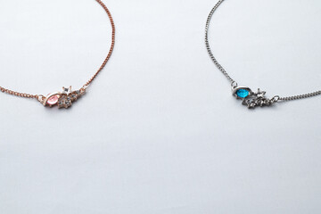 Silver chain necklaces with blue and red diamond pendant on white background