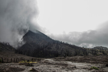 Partially cloudy volcanic cone in the middle of the forest burned by volcanic activity in the Turrialba Volcano National Park in Costa Rica