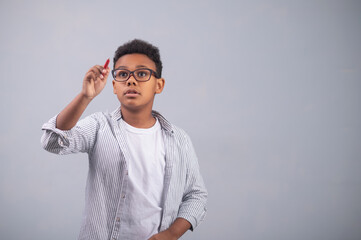 Fototapeta premium Serious concentrated kid drawing with a pencil