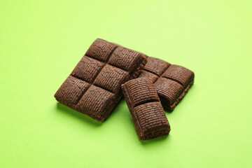 Pieces of delicious hematogen on green background